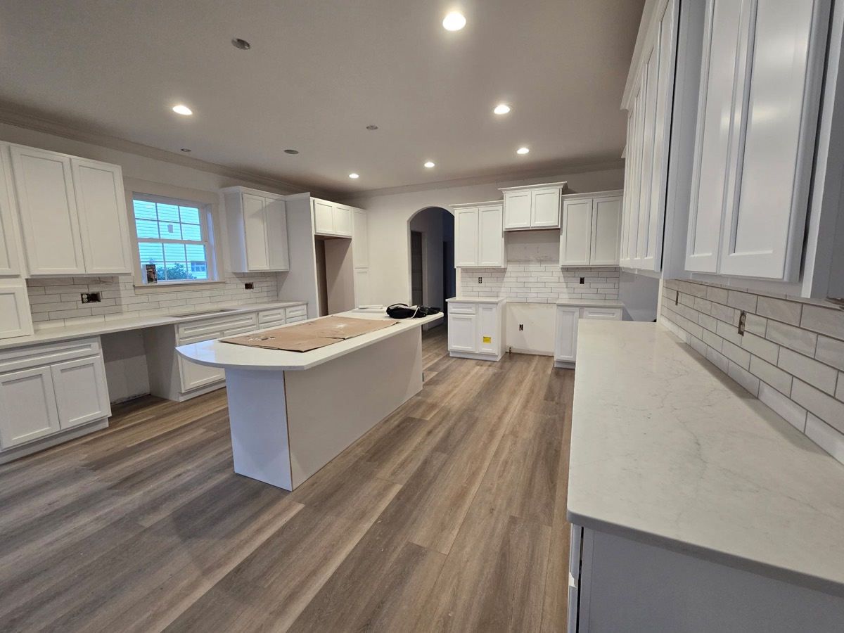 Remodeled kitchen with island and vinyl plank flooring