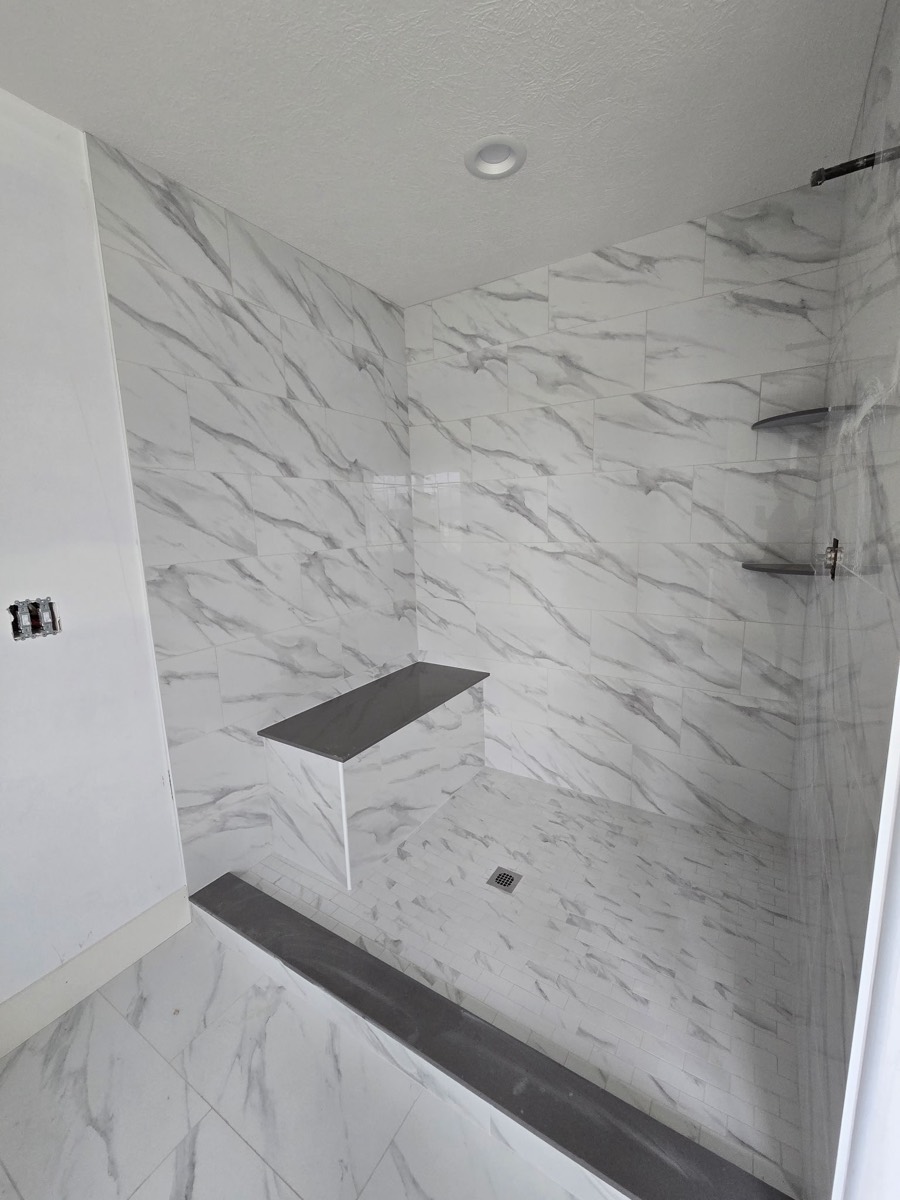Custom marble-look tile shower with bench